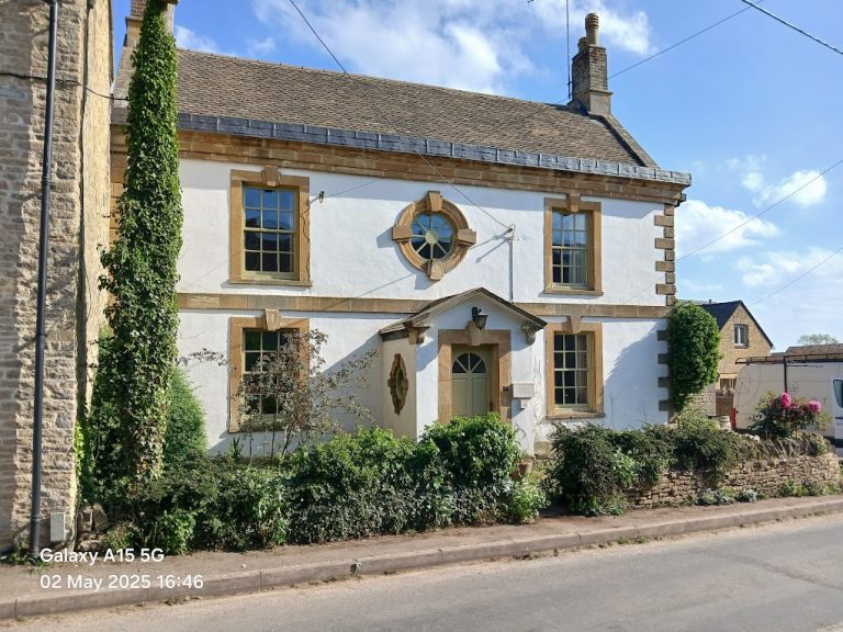Completed Grade II listed Cotswold stone home with inset solar panels on the rear roof